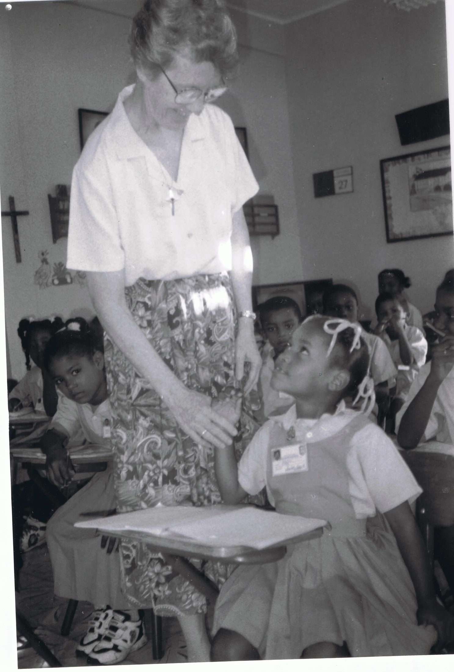 Sor Leonor conversa con una niña dentro del aula.